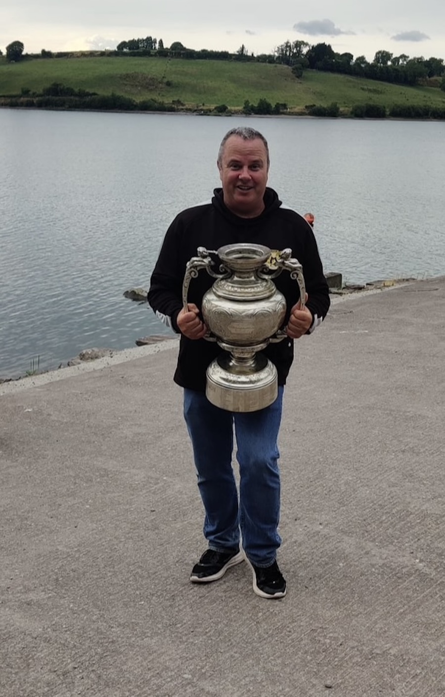 Noel Carey rowing coach holding trophy